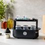 Open black steam steriliser on a kitchen counter with baby bottles inside