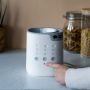 Person pouring water into the advanced bottle warmer above text about warming feeds fast