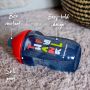 Blue sippee cup lying flat on a carpet with pointers to its bite resistant spout, spill proof lid and easy hold body