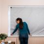 Femme installant le store occultant sur une fenêtre