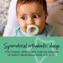 Baby with green breast-like night soother in mouth with describing the benefits of the symmetrical orthodontic design.