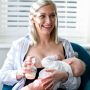 Woman using manual breast pump on one breast while breastfeeding baby from the other