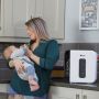 mum feeding baby with uv sterilizer in foreground