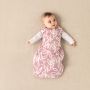 baby in Tommee Tippee botanical snuggle with both hands extended and eyes looking in one direction 