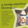 Tasse grise avec paille sur table en extérieur, avec texte sur la paille BACSHIELD antibactérienne