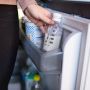 Someone placing a filled milk storage pouch in the fridge
