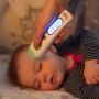 baby-sleeping-whilst-parent-uses-no-touch-forehead-thermometer
