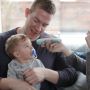 dad-holding-baby-whilst-using-no-touch-forehead-thermometer