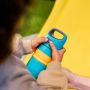 Enfant appuyant sur le couvercle de sa tasse Sportee bleue à couvercle rabattable