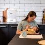 Woman feeding her baby in the kitchen with a Steridryer behind her