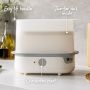 White steam sterilizer on kitchen counter with pointers to its easy-lift handles, one-button start and two-tier rack