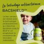 Tasse d&apos;apprentissage verte sur table en extérieur, avec texte sur le bec antibactérien BACSHIELD