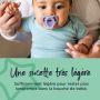 Bébé assis avec la sucette dans la bouche en tenant la main de ses parents.