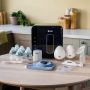 Photo of the products in the express to feed bundle, including a wearable pump, UV steriliser, bottle warmer and baby bottles in a home setting.