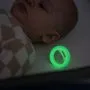 Baby sleeping with glowing in the dark pacifier next to them