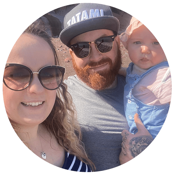 parents wearing sunglasses holding their baby