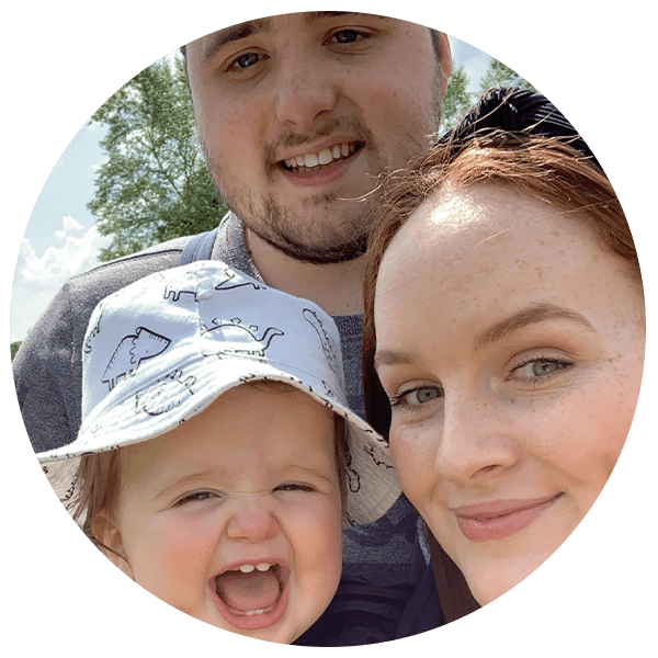 a mum, dad and their baby who is wearing a sun hat