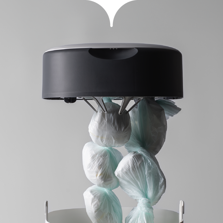 Une poubelle à couches Twist & Click avec le couvercle soulevé, montrant le film de recharge rempli de couches.