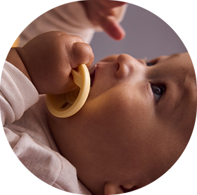 a baby putting a tommee tippee breast-like soother in his mouth