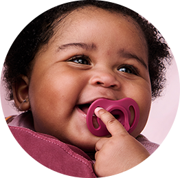 a baby putting a tommee tippee breast-like soother in his mouth