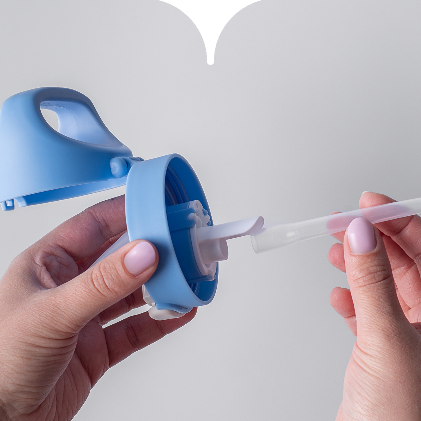 Close up image of hands attaching the straw to the bottom of a Tommee Tippee straw cup valve. 