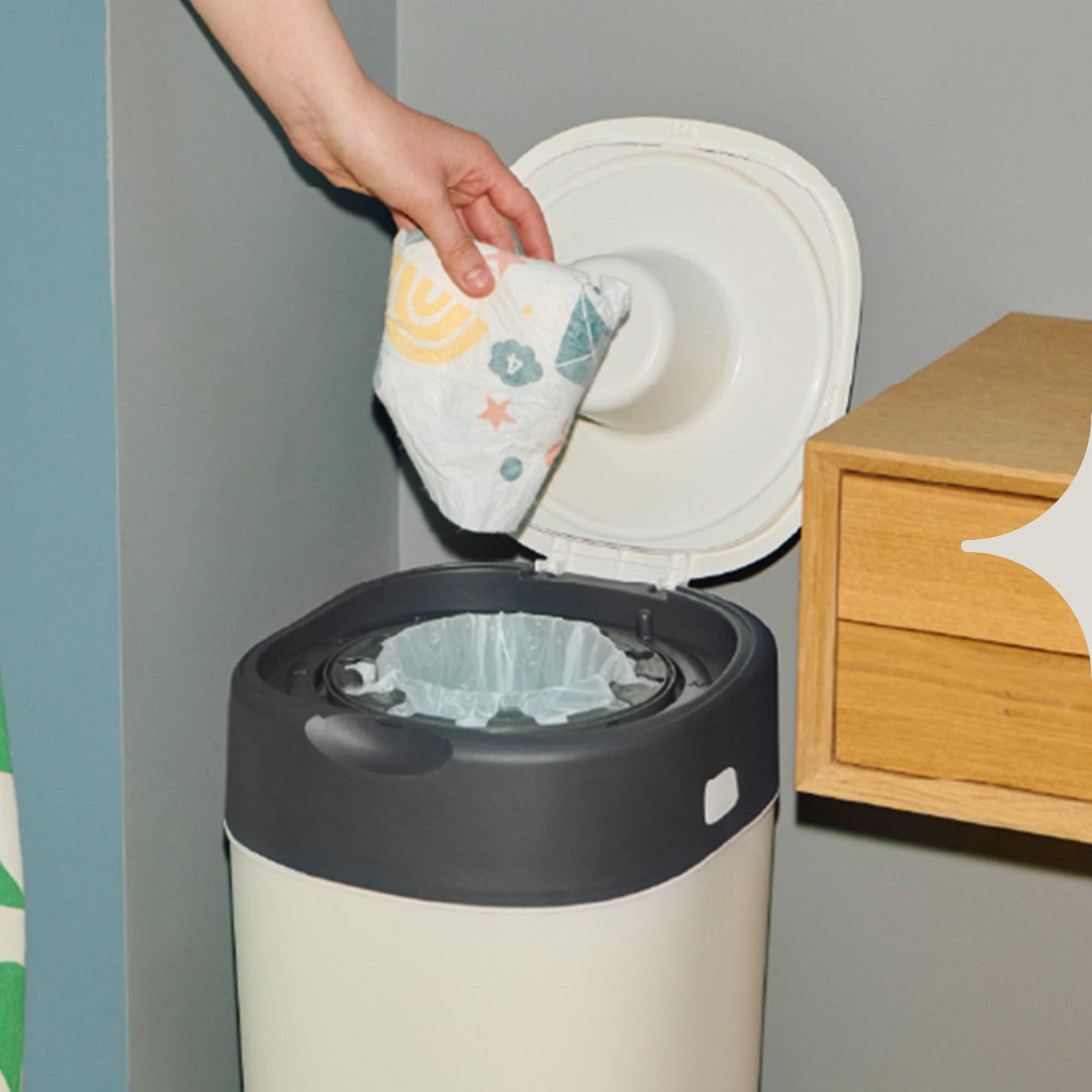 Image of someone dropping a used nappy into the Twist & Click nappy bin.