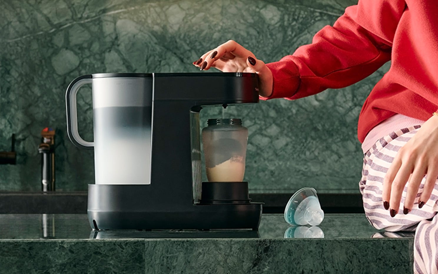 a mum making a baby bottle using a perfect prep machine 