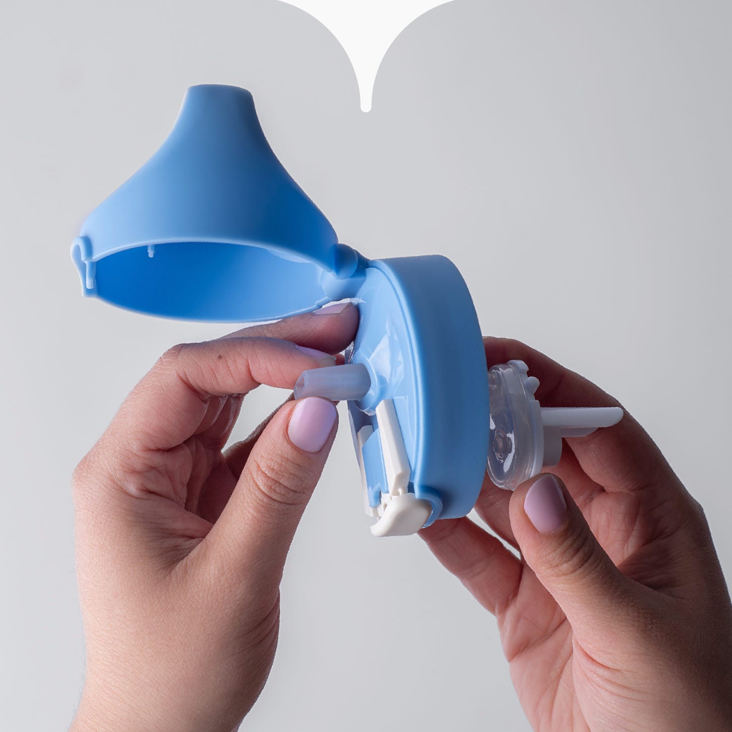 Close up image of hands attaching the soft straw (and connecting cup valve) through a Tommee Tipppe cup lid. 