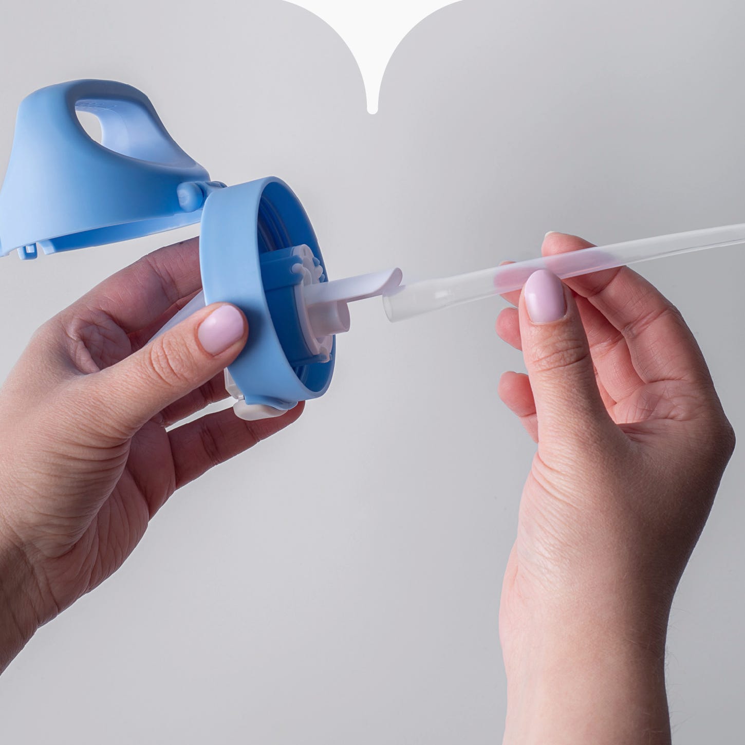 Close up image of hands attaching the straw to the bottom of a Tommee Tippee straw cup valve. 