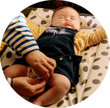 A mum feeding her baby using a tommee tippee wearable breast pump