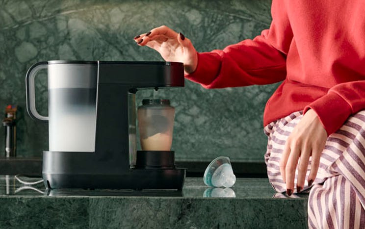 a mum making a baby bottle using a perfect prep machine 