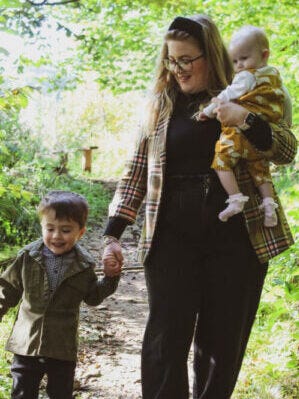 Mum walking in a forest with her two children